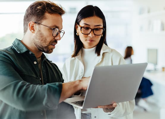 Mann und Frau vor Laptop in Diskussion